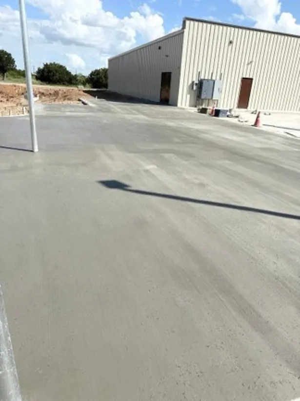 Finished lot and apron at a white metal warehouse building