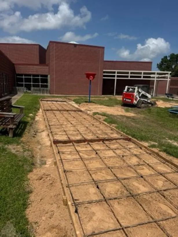Walkway formed and tied out alongside a brick school building