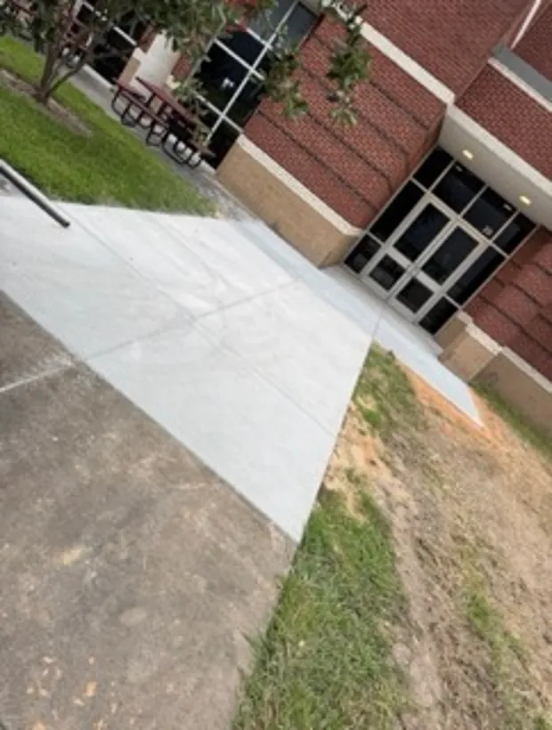 Finished concrete ramp and walkway at a brick school building