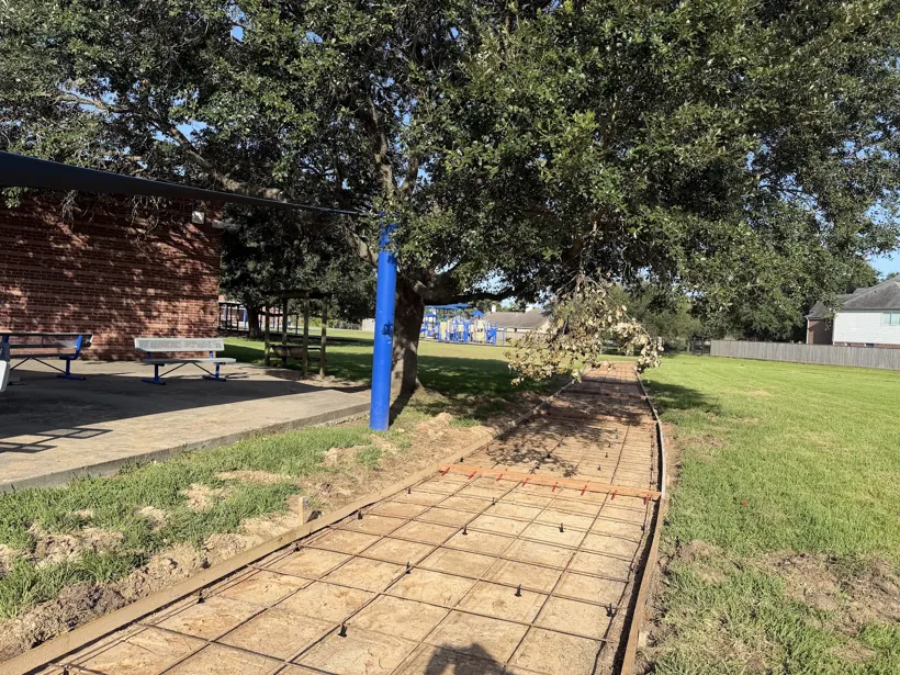 Formed walkway running past a brick building and picnic area