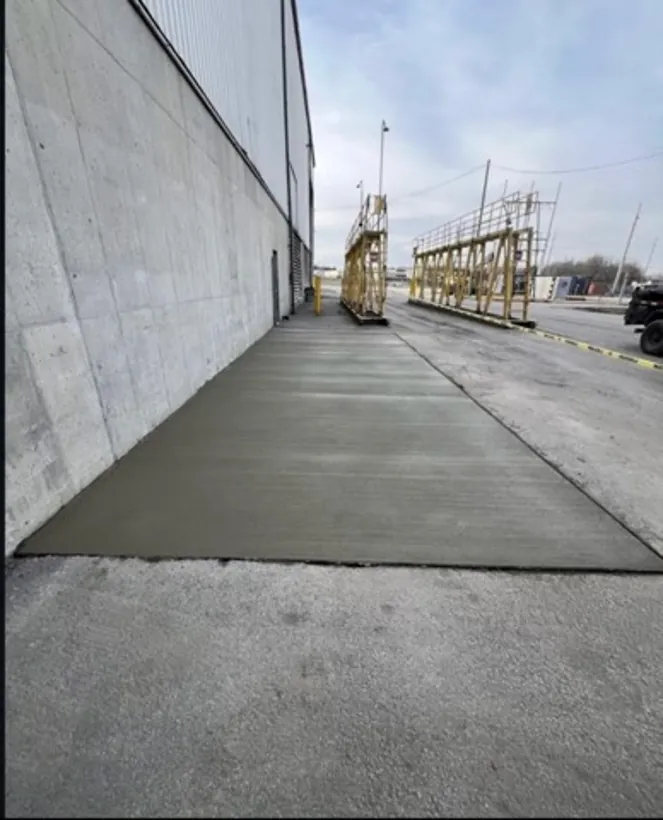 Long finished walkway between a commercial building and the lot