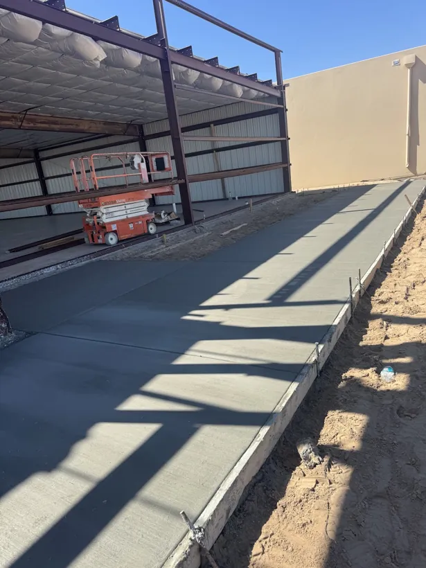 Finished concrete walk beneath a covered steel structure