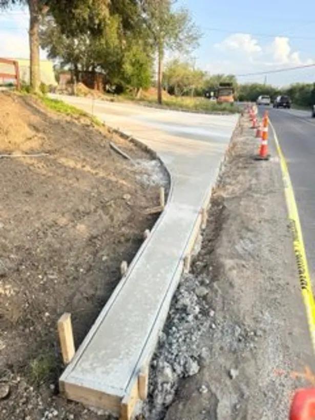 Curb and gutter poured along a roadway with traffic control
