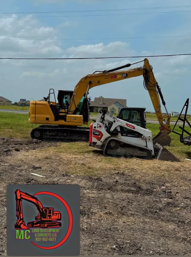 Excavator and track skid steer working a commercial lot