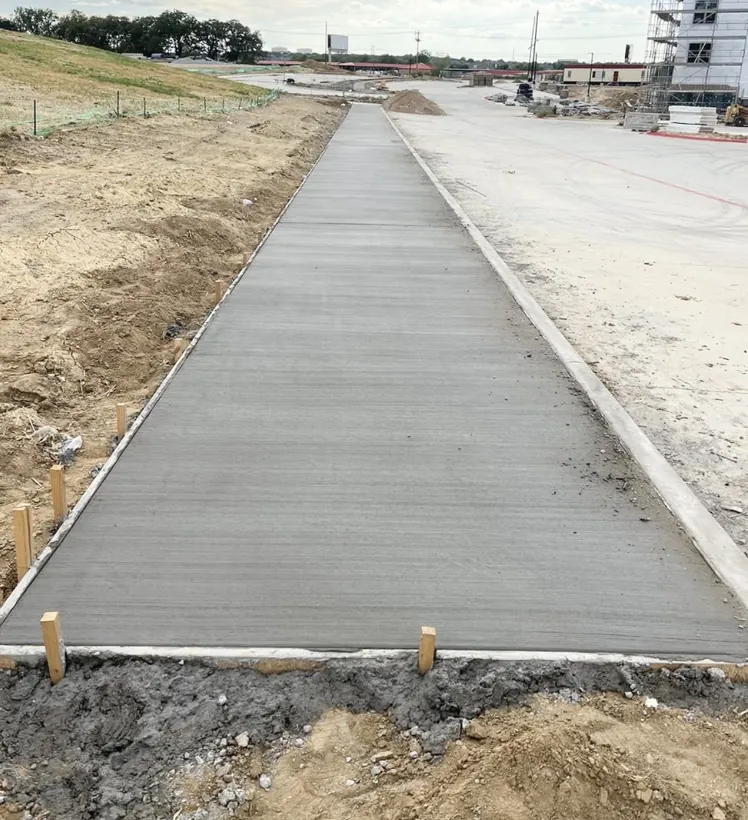 Long commercial concrete walkway finished along a roadway