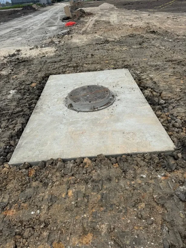 Poured in place concrete vault lid with manhole opening set to grade