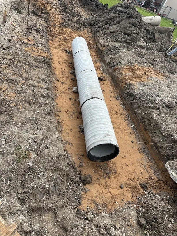 Large diameter culvert pipe set in a trench for site drainage