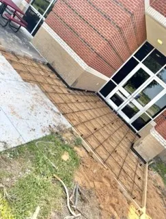 Walkway rebar tied out at the entrance of a brick school building