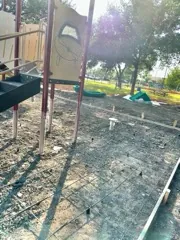 Pad formed under a playground structure before the pour