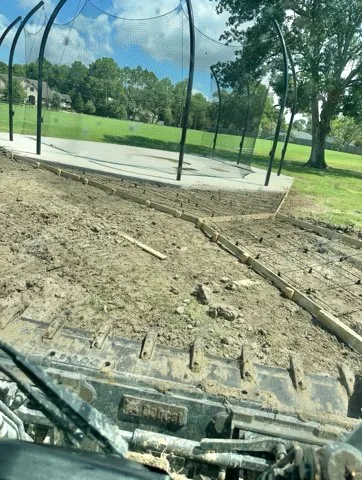 Walkway formed beside a steel pavilion, seen from the skid steer