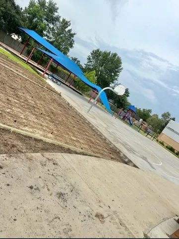 Finished walkway running past a playground and basketball court