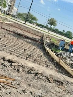 Rebar mat and curb forms set along a roadway with the crew at work